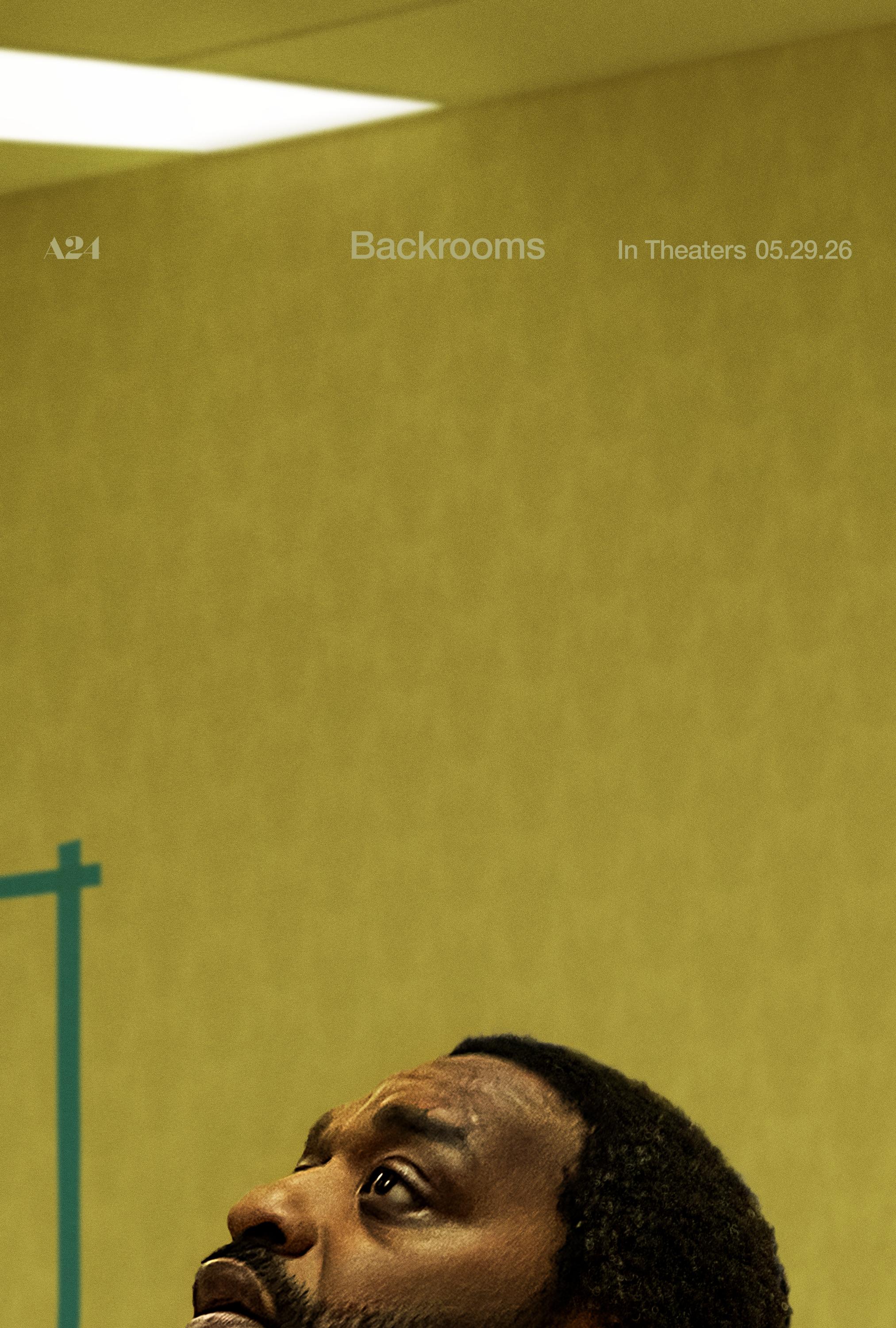 A pattern of different yellow tones wall paper in the background. An actor looking up to the ceiling light.