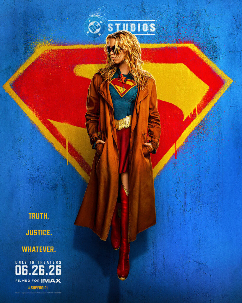 Supergirl is wearing an overcoat. Supergirl logo and blue wall in the background.